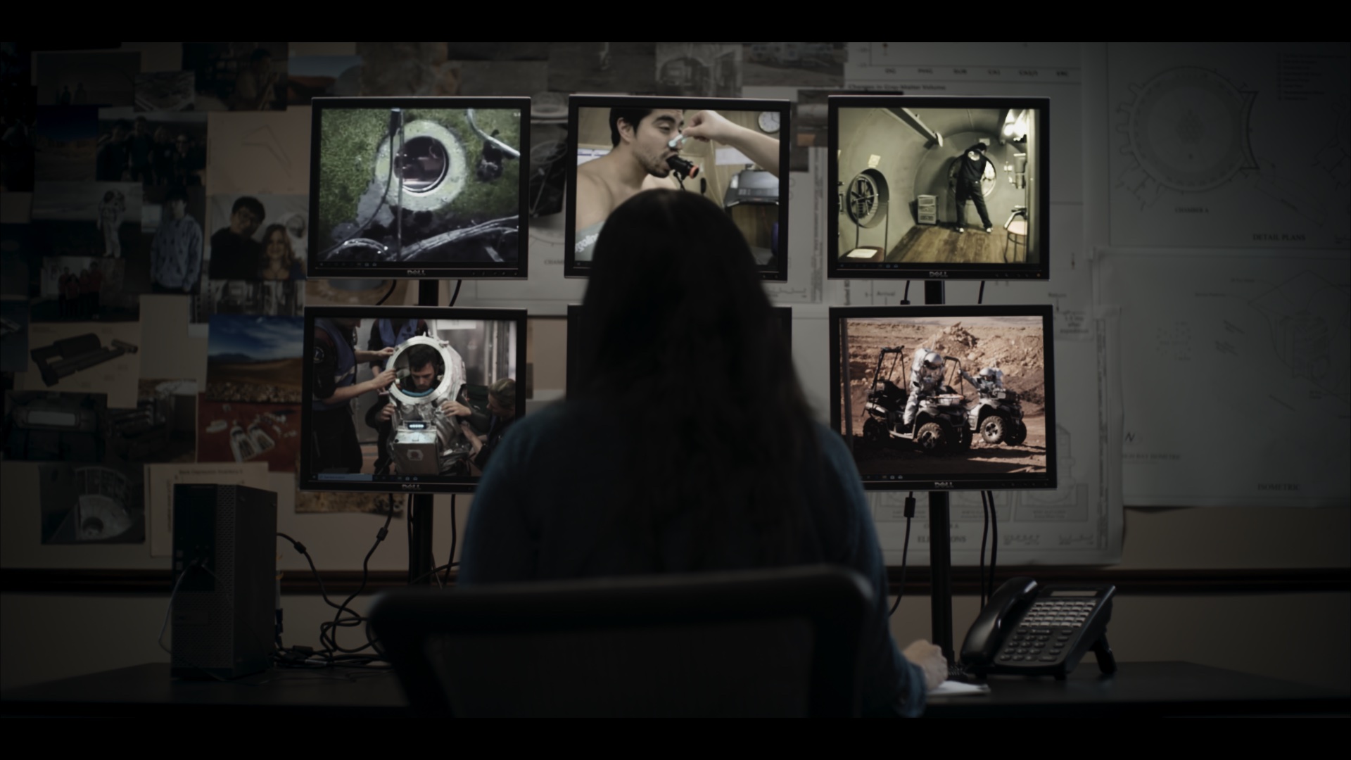 Researcher studying space simulation footage across multiple monitors
